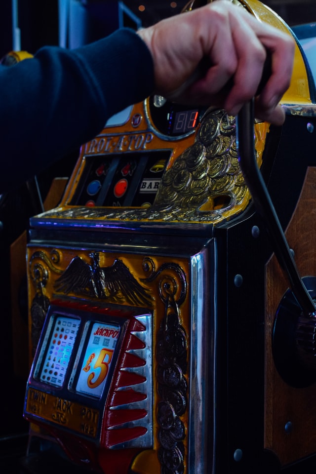 Person drar i en spak på en äldre spelautomat.